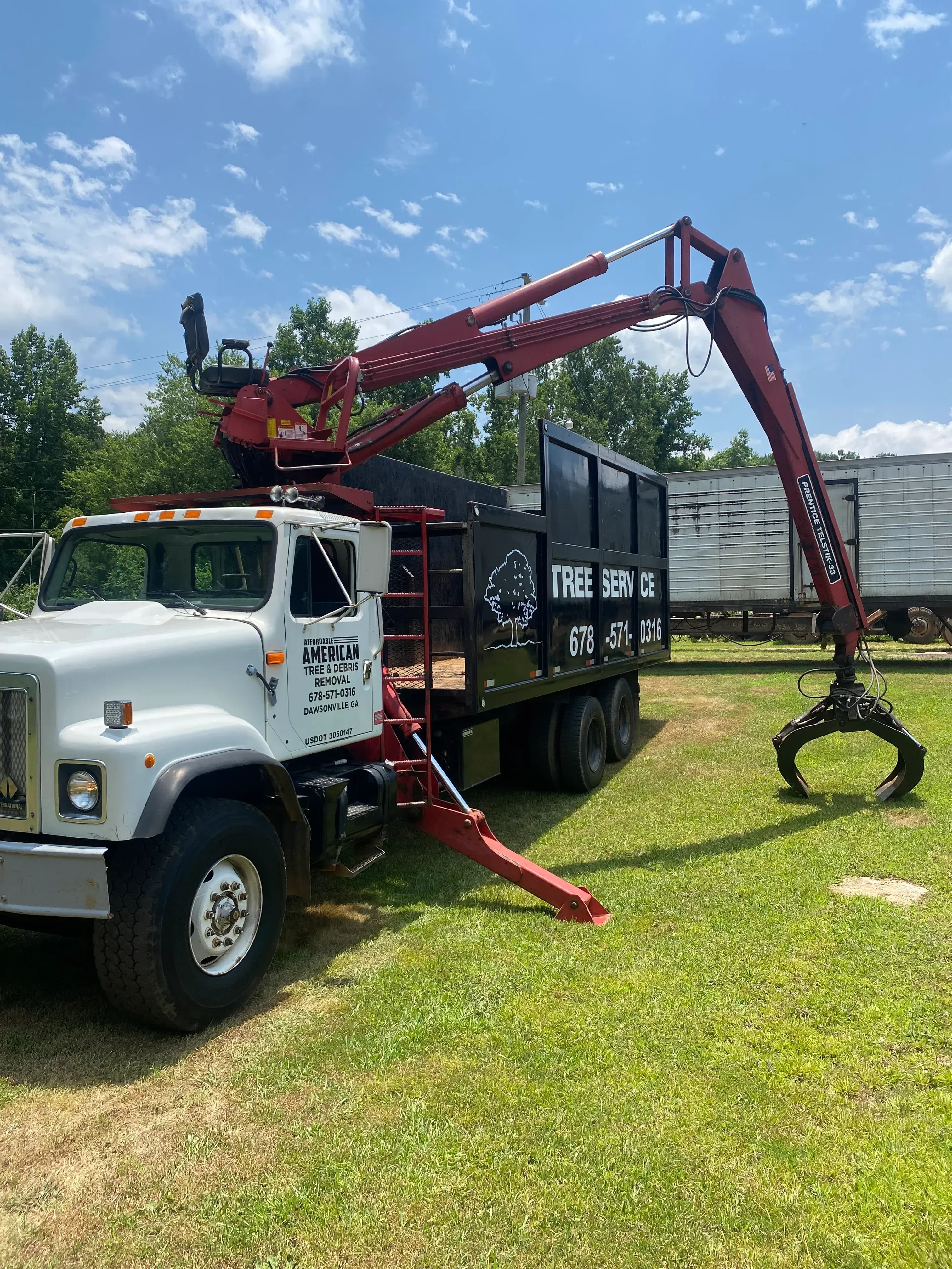 Commercial tree service truck with red hydraulic crane and wood chipper equipment