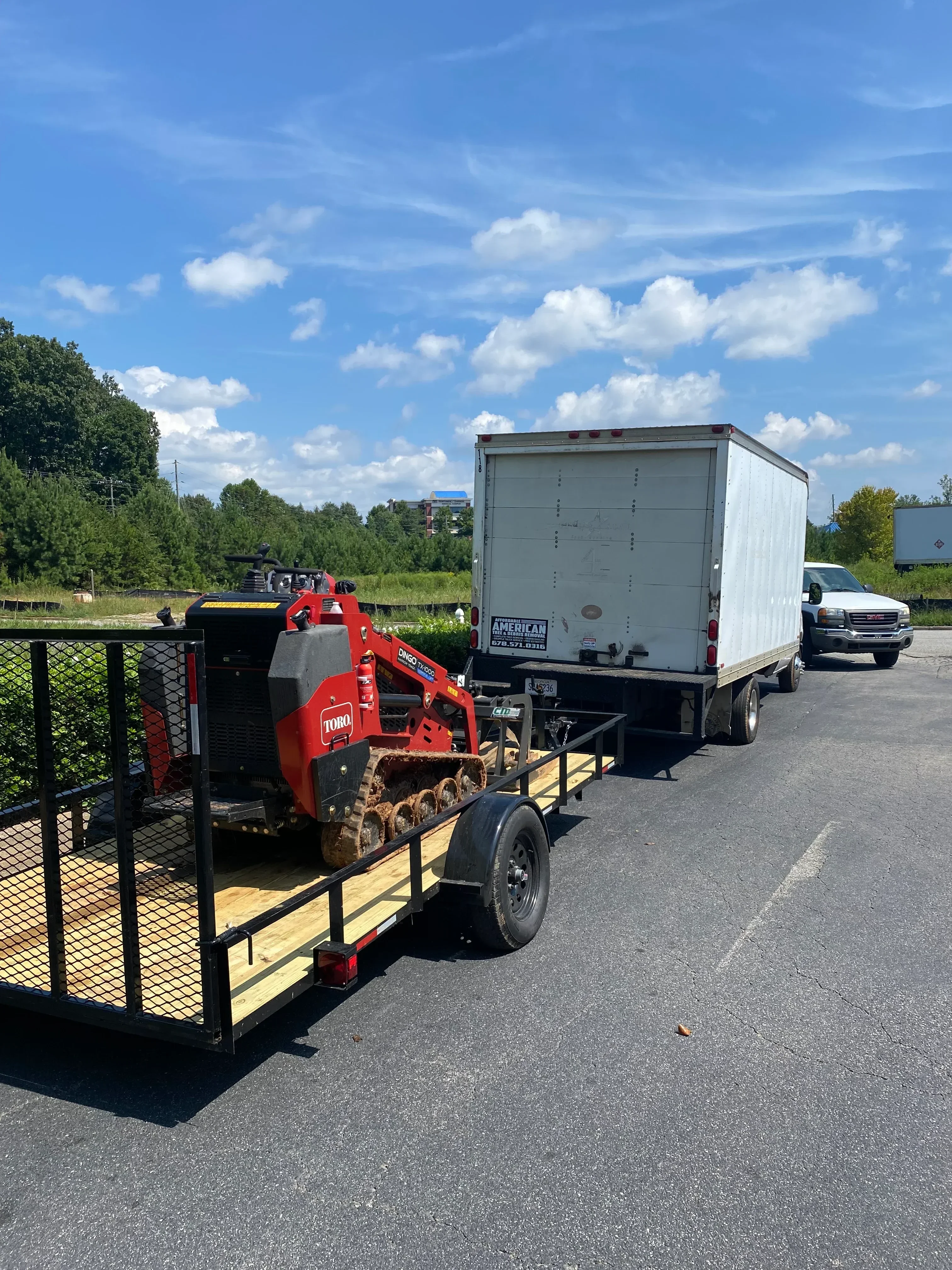 Red dump truck with hydraulic lift gate loaded with wood chips and tree debris on flatbed