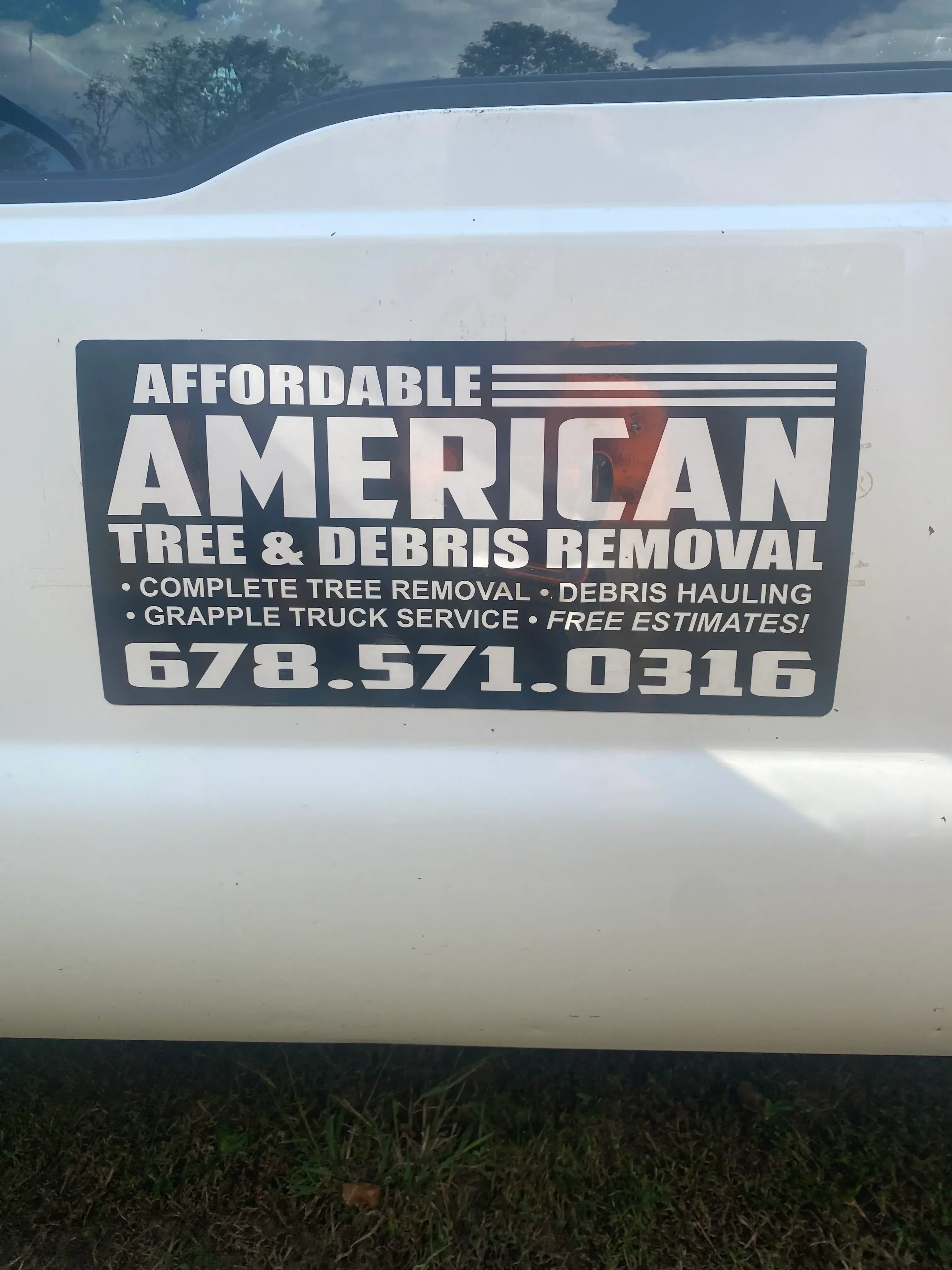 Custom vinyl truck signage with company name, services, and phone number on white vehicle door