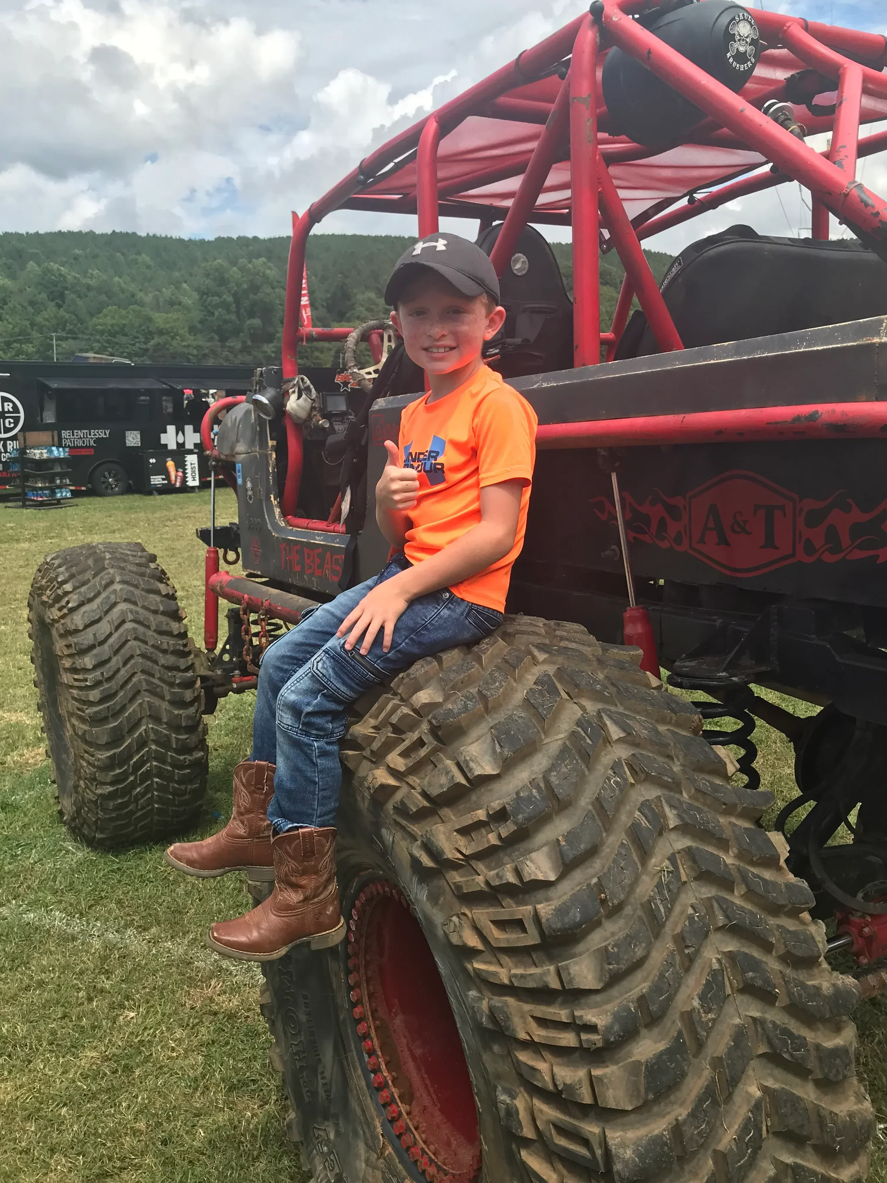 Large agricultural tire with deep tread pattern mounted on red equipment frame