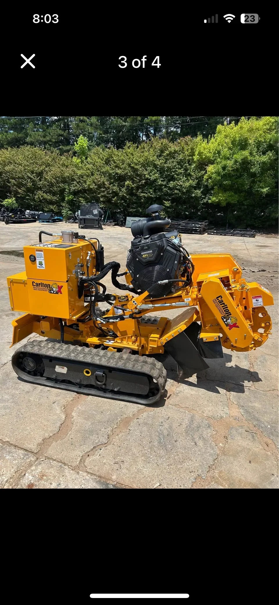 Yellow Carlton stump grinder with tracked base and black grinding head on concrete surface