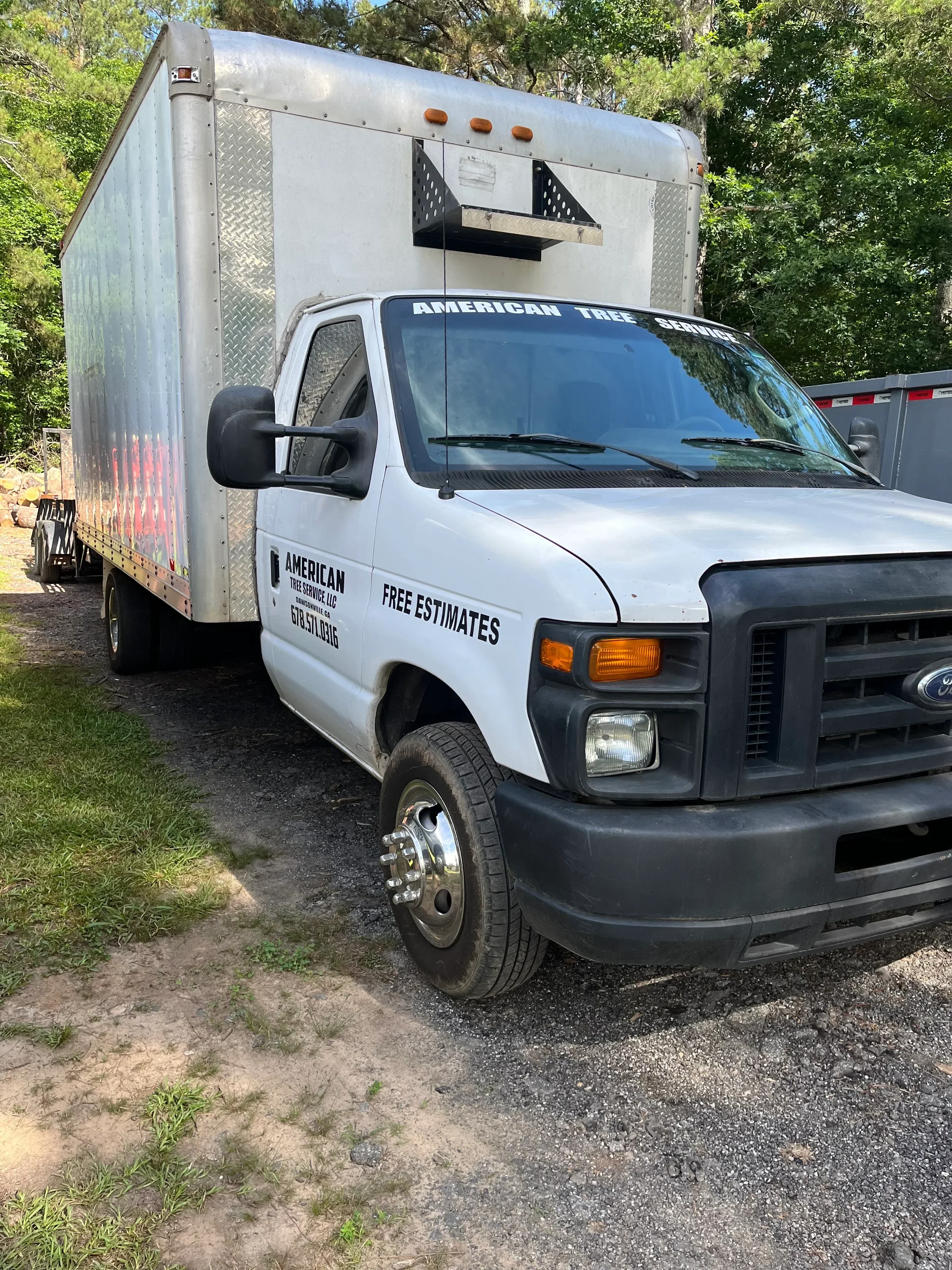 White pickup truck with custom vinyl wrap and enclosed aluminum trailer
