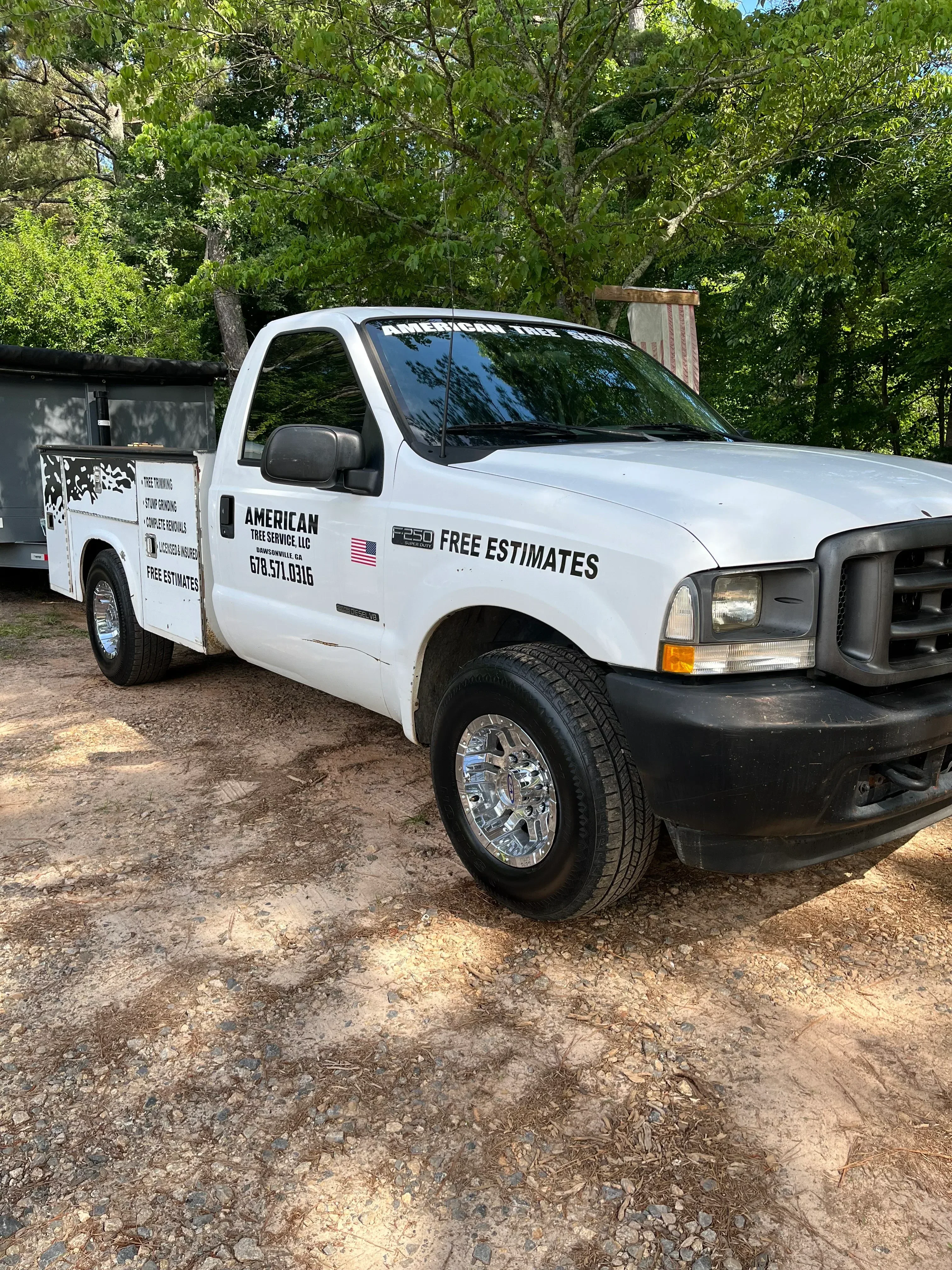 White service truck with custom vinyl wrap and company branding on dirt road