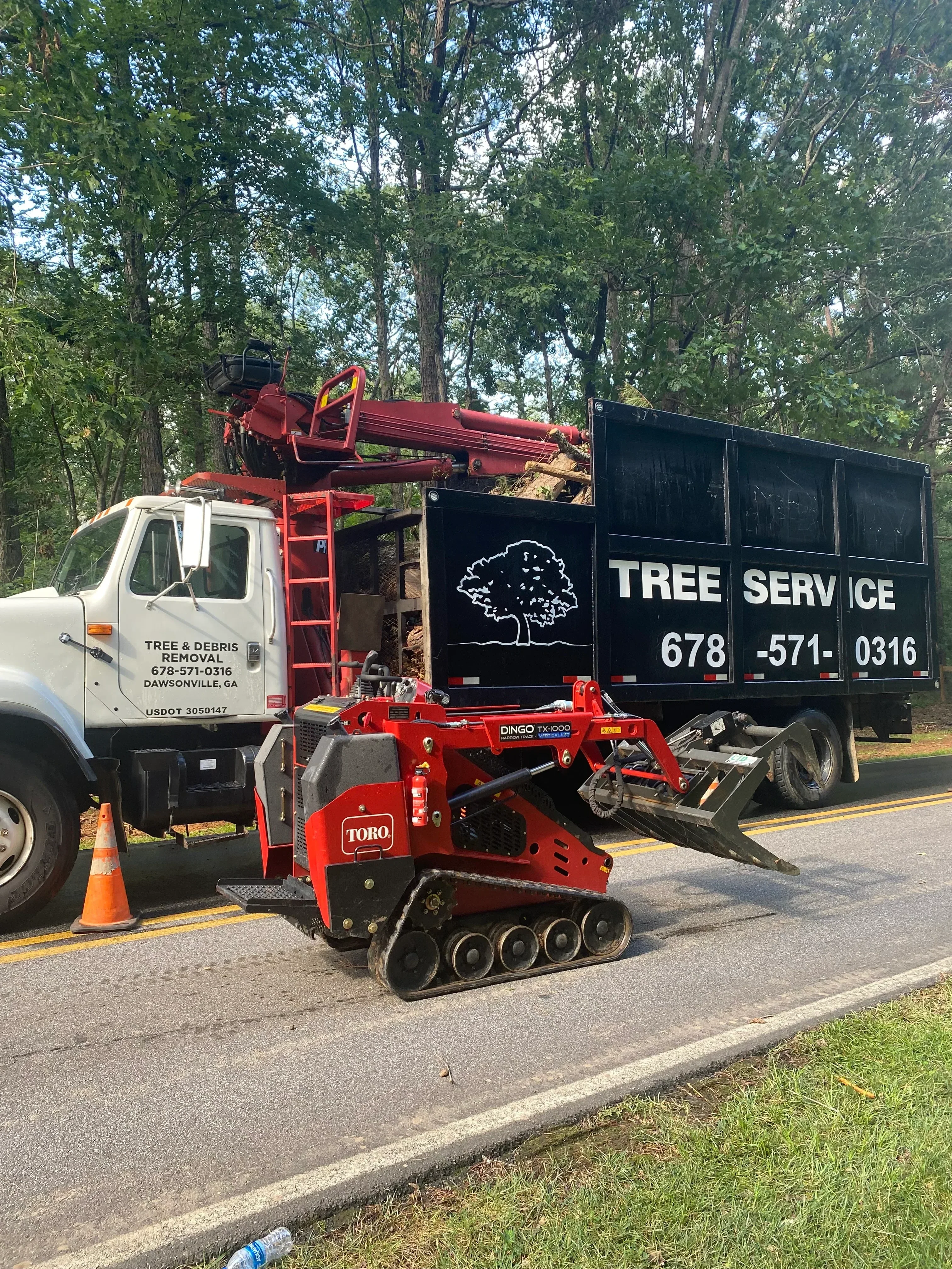 Red wood chipper and bucket truck during tree removal with debris processing equipment
